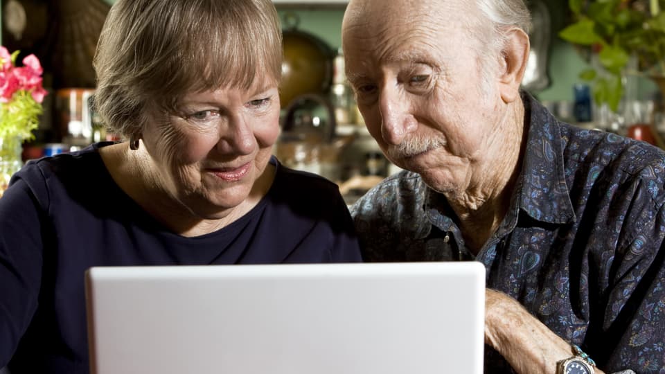 Pensionärer framför dator