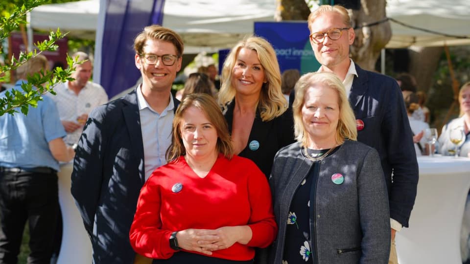 Tre kvinnor och två män i utomhusmiljö som tittar rakt in i kameran.