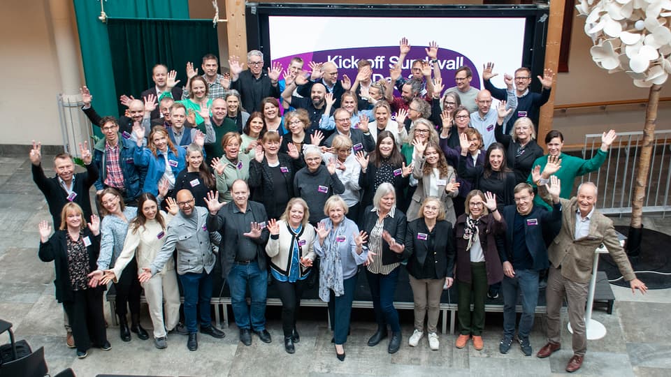 Group of smiling people raising their hands