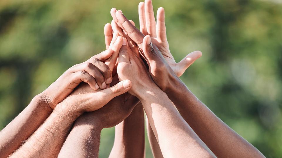 Flera händer som möts tillsammans i en high five