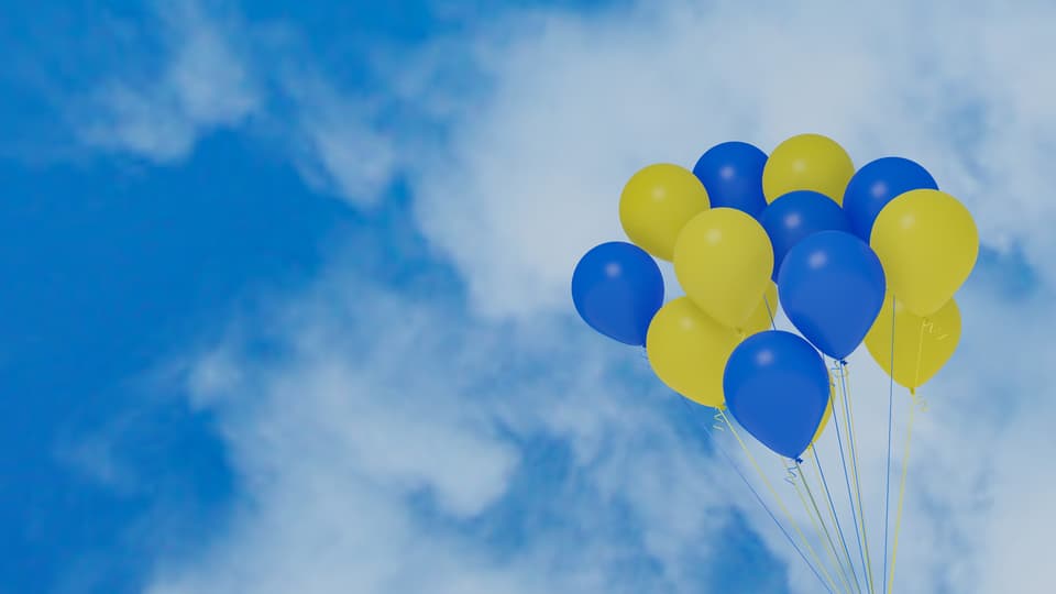Gula och blå ballonger mot en blå himmel