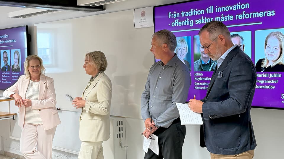 En panel med fyra personer under ett seminarium